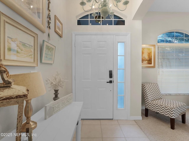 entryway featuring an inviting chandelier, a wealth of natural light, and light tile patterned floors