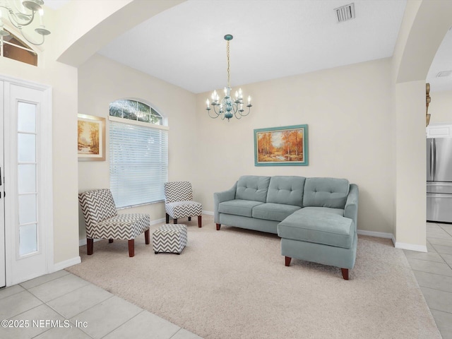 carpeted living room featuring a chandelier