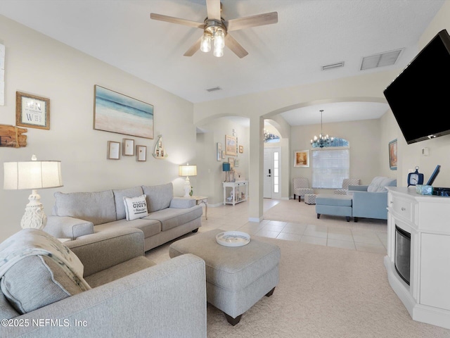 living room with ceiling fan with notable chandelier and light tile patterned floors