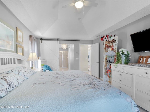 bedroom with ceiling fan, a barn door, and vaulted ceiling