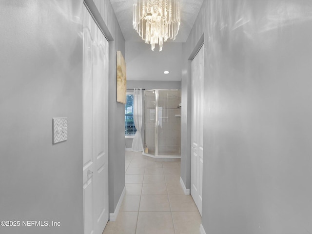 hallway featuring light tile patterned floors and a chandelier