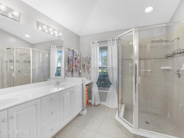 bathroom featuring vanity, a wealth of natural light, tile patterned floors, and a shower with shower door