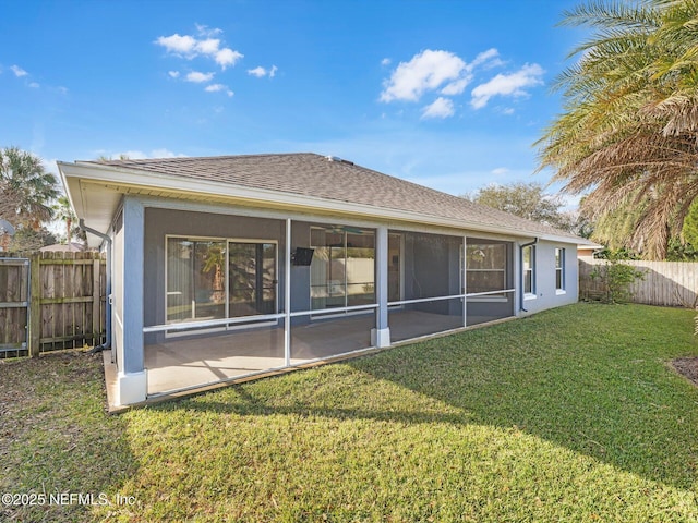 rear view of property featuring a sunroom and a yard