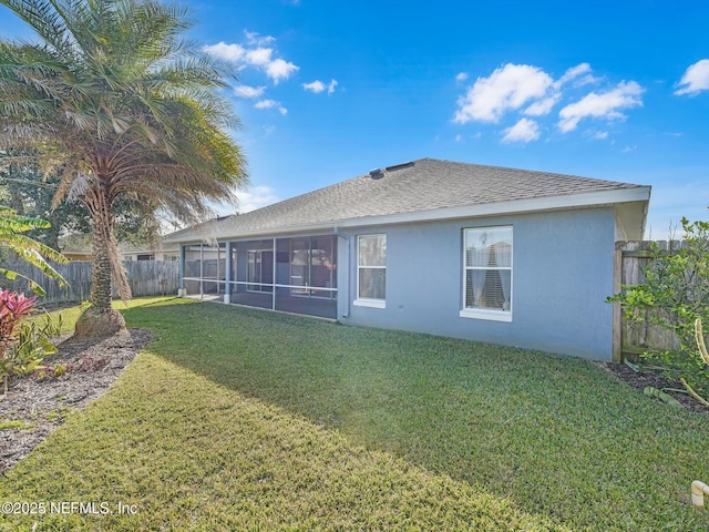 back of property featuring a sunroom and a yard