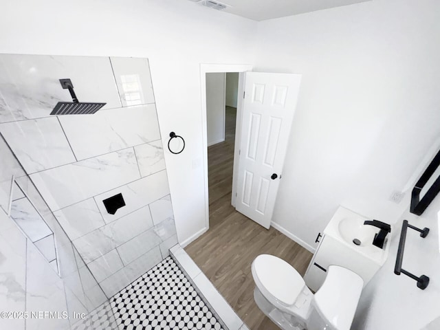 bathroom with toilet, hardwood / wood-style floors, vanity, and walk in shower