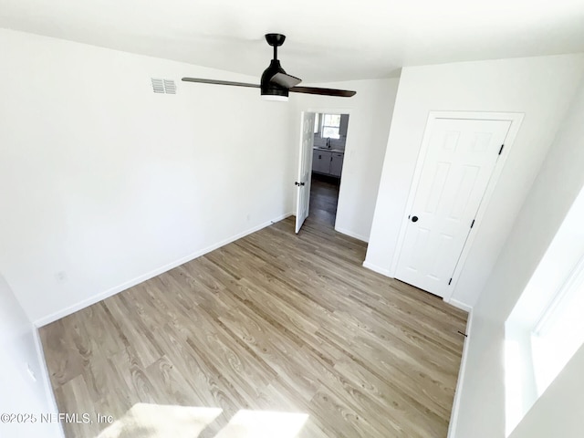 empty room featuring ceiling fan and light hardwood / wood-style floors