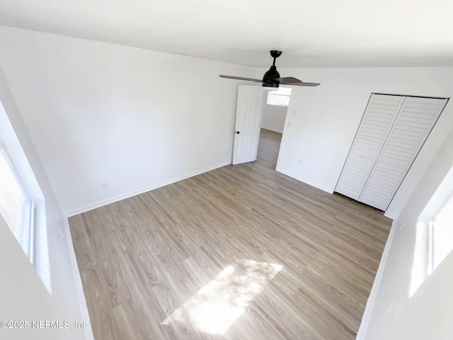 unfurnished bedroom with light hardwood / wood-style flooring, ceiling fan, and a closet