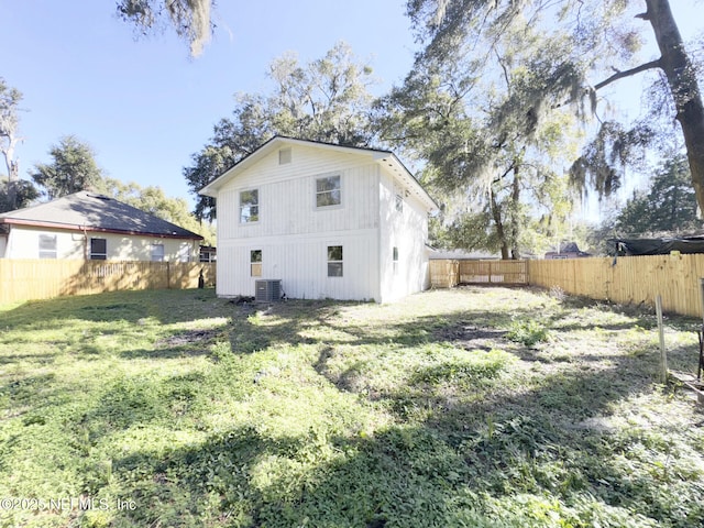 rear view of property with a yard and central AC unit