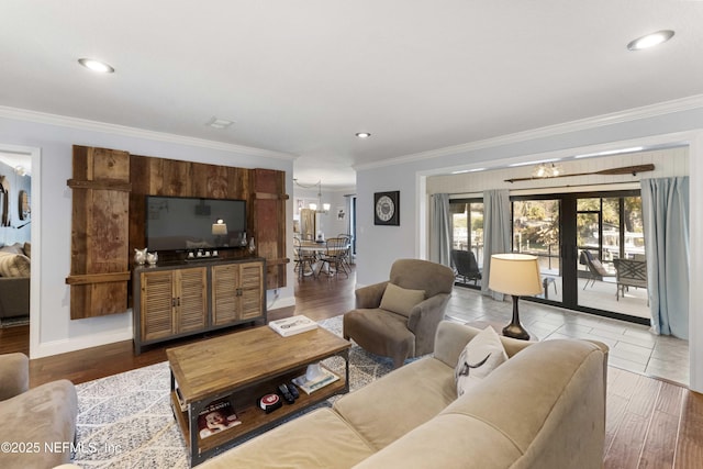 living room with crown molding, french doors, a chandelier, and hardwood / wood-style flooring