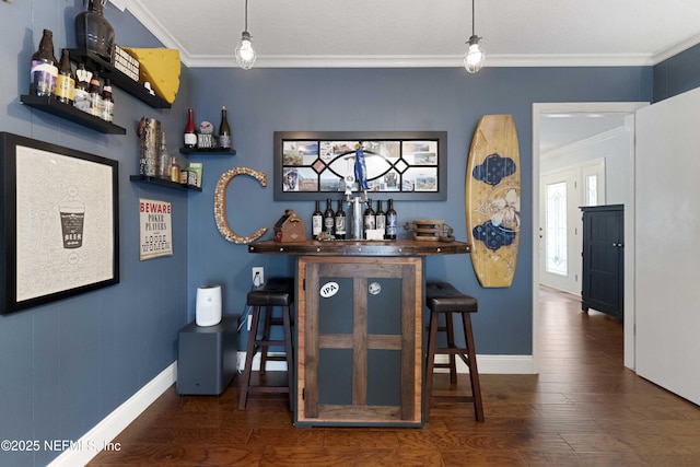 bar featuring dark hardwood / wood-style flooring, decorative light fixtures, and ornamental molding