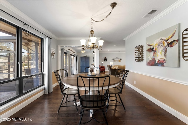 dining room with crown molding, dark hardwood / wood-style floors, and a chandelier