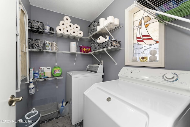 laundry room featuring washing machine and dryer and a textured ceiling