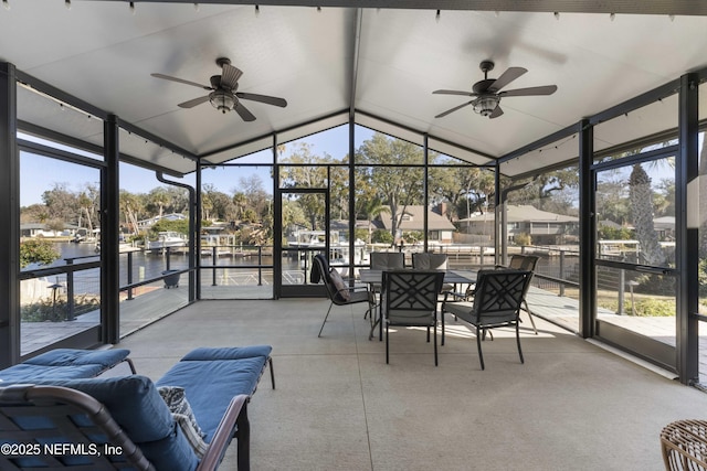 sunroom featuring lofted ceiling, a wealth of natural light, ceiling fan, and a water view