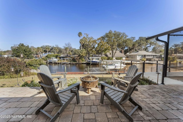 view of patio / terrace featuring a water view, a dock, and a fire pit