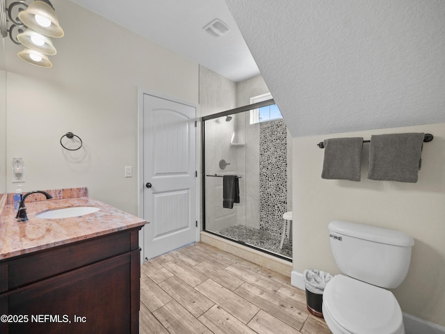 bathroom with vanity, toilet, and a shower with door