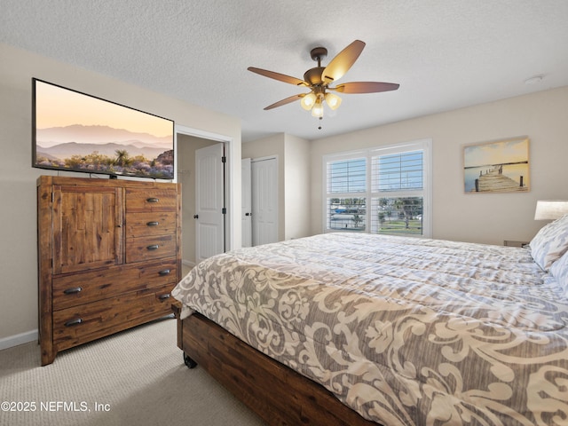 bedroom with light carpet, a textured ceiling, ceiling fan, and a closet