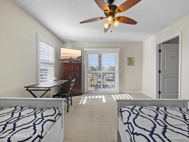 bedroom featuring ceiling fan, access to exterior, carpet floors, and a textured ceiling