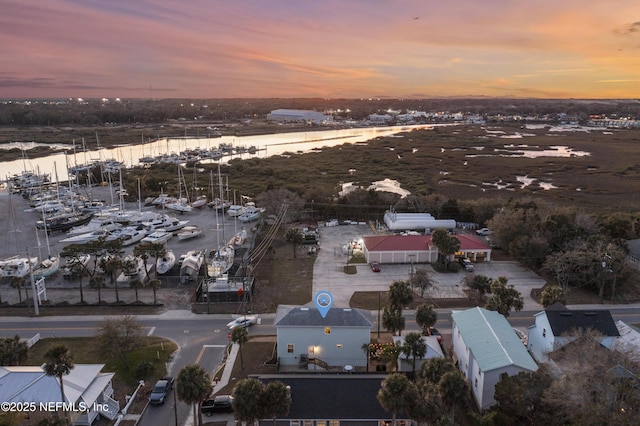 aerial view at dusk featuring a water view