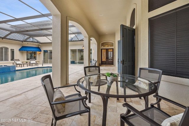 view of patio featuring glass enclosure