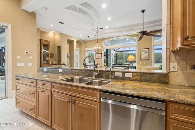 kitchen featuring tasteful backsplash, stone countertops, dishwasher, and sink