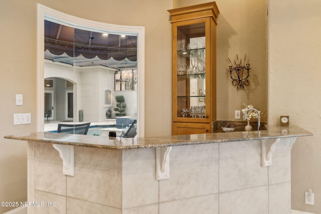 bar featuring light stone countertops