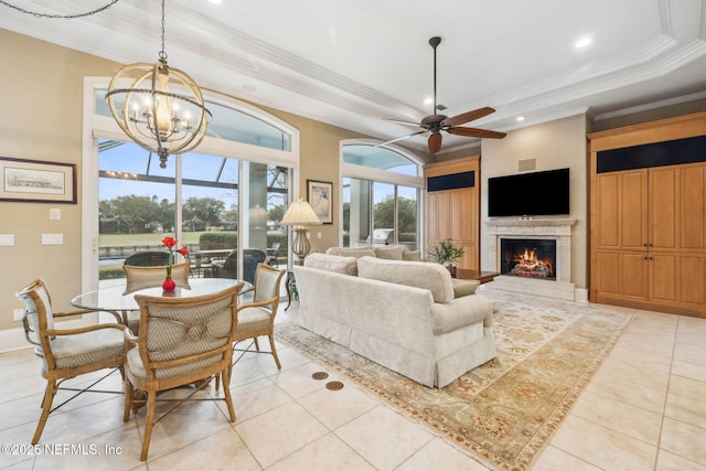 tiled living room with ornamental molding, a tray ceiling, and ceiling fan with notable chandelier