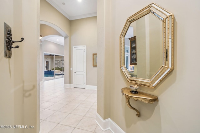 hallway featuring ornamental molding and light tile patterned floors