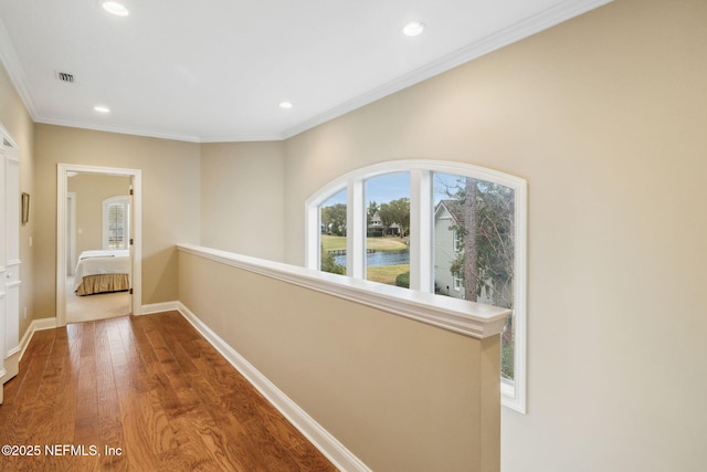 hallway with crown molding and hardwood / wood-style flooring