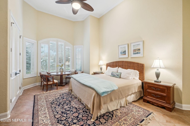 tiled bedroom with ornamental molding, a towering ceiling, and ceiling fan