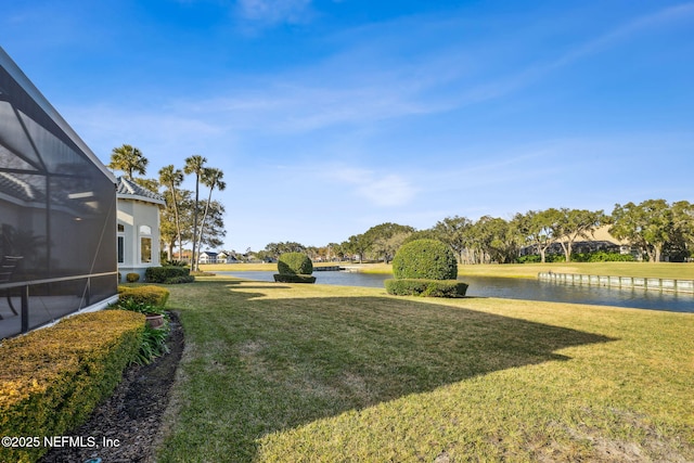 view of yard with glass enclosure and a water view