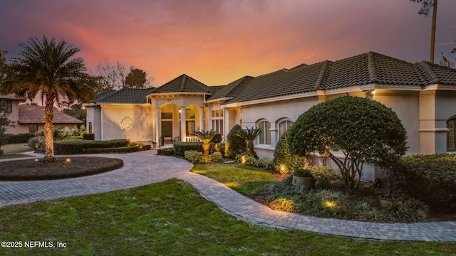 mediterranean / spanish house featuring a yard