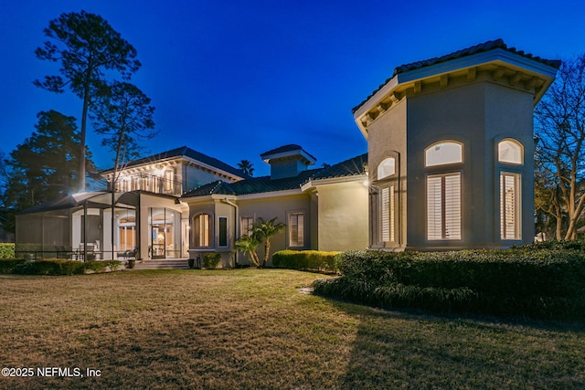 exterior space with a balcony, a lanai, and a lawn