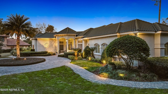 mediterranean / spanish-style home featuring a front lawn