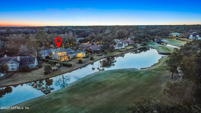 aerial view at dusk featuring a water view