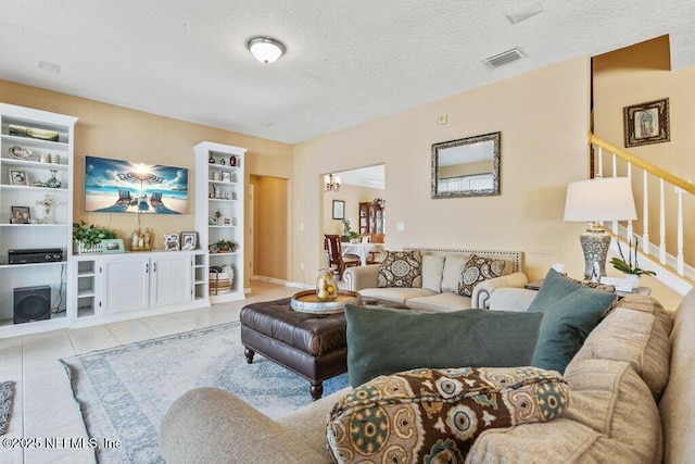 tiled living room featuring an inviting chandelier, built in features, and a textured ceiling