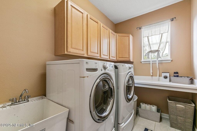 laundry room with cabinets, sink, washer and dryer, and light tile patterned floors