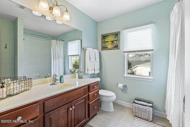 bathroom featuring vanity, tile patterned flooring, toilet, and a healthy amount of sunlight