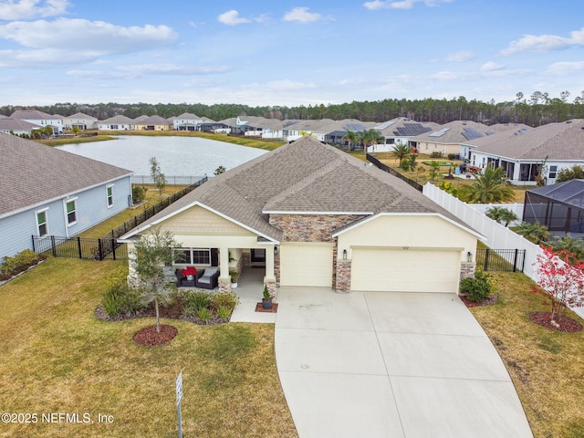 view of front of property featuring a garage, a water view, and a front lawn