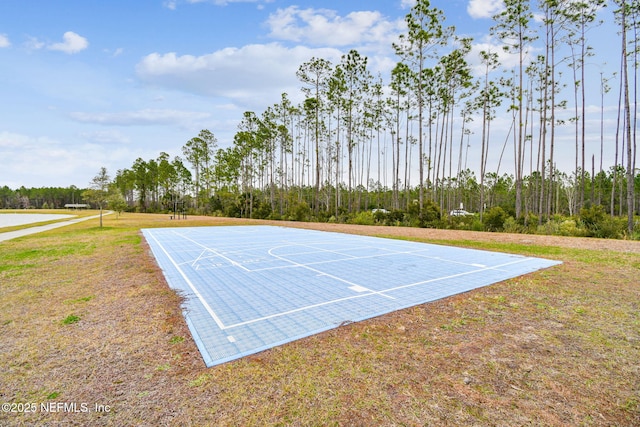 view of sport court with a lawn