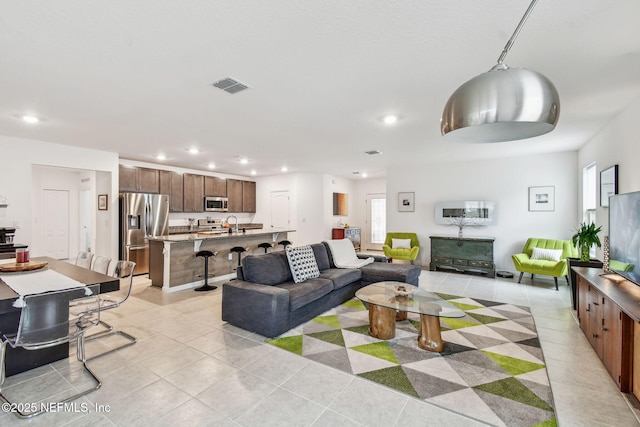 living room featuring sink and light tile patterned floors