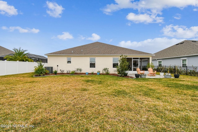 rear view of house featuring a yard, a patio area, a sunroom, and central AC