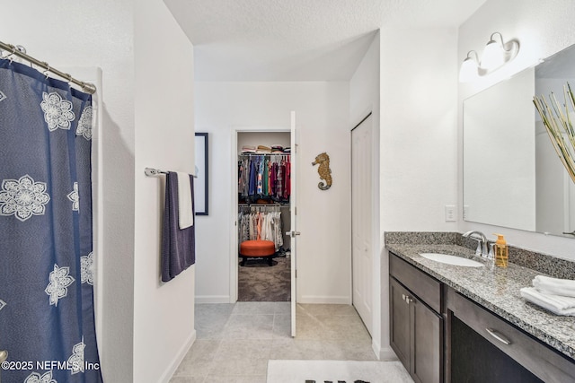 bathroom with vanity, tile patterned flooring, and a textured ceiling