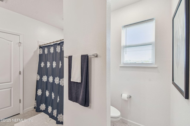 bathroom with a shower with shower curtain, toilet, and tile patterned flooring