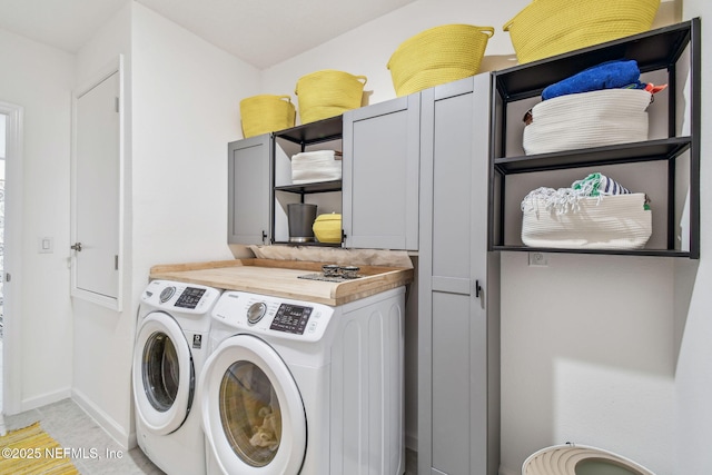 laundry room featuring independent washer and dryer, cabinets, and light tile patterned flooring