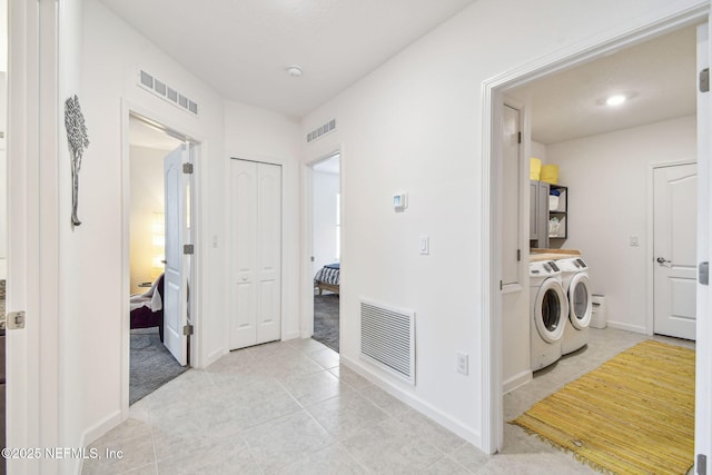 clothes washing area with separate washer and dryer and light tile patterned floors