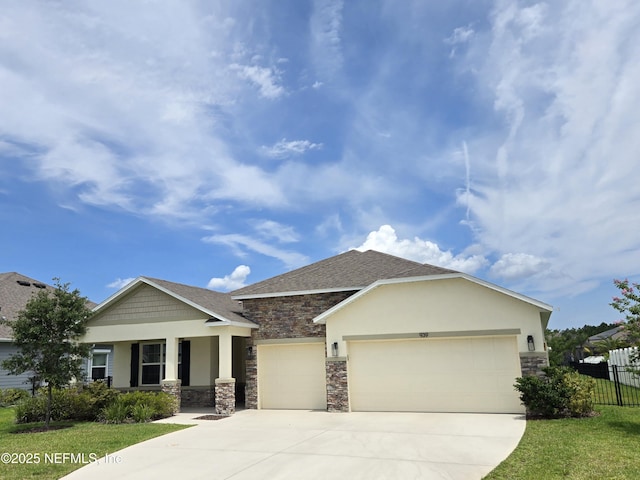 939 Ocean Jasper Dr, Saint Augustine, FL 32086 - view of front of home featuring stone siding, a garage, concrete driveway, covered porch, and stucco siding