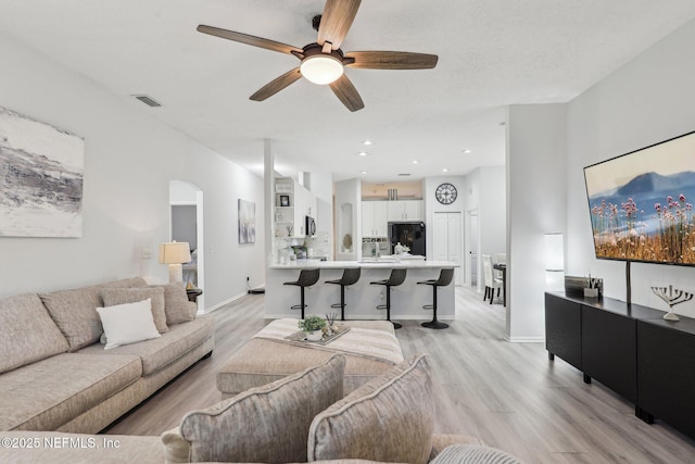 living room featuring light hardwood / wood-style flooring and ceiling fan