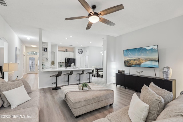 living room with ceiling fan and light wood-type flooring