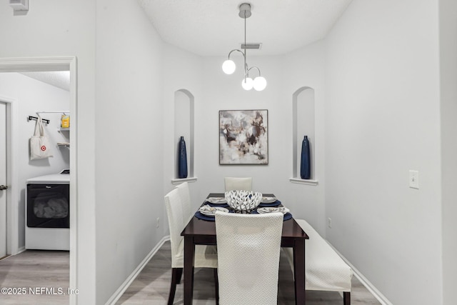 dining area with washer / clothes dryer and light hardwood / wood-style floors