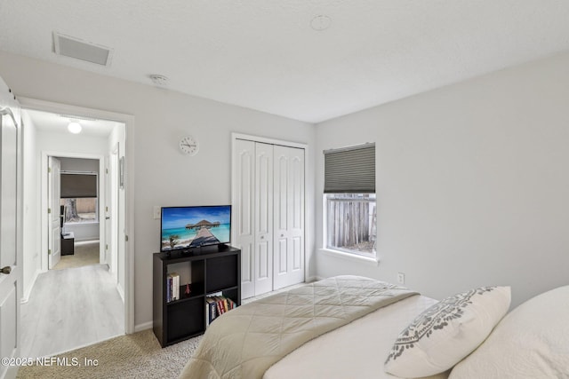 bedroom featuring light carpet and a closet